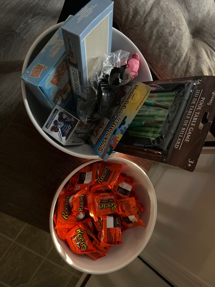 A bowl of Reese’s cup candy and a bowl containing random toys