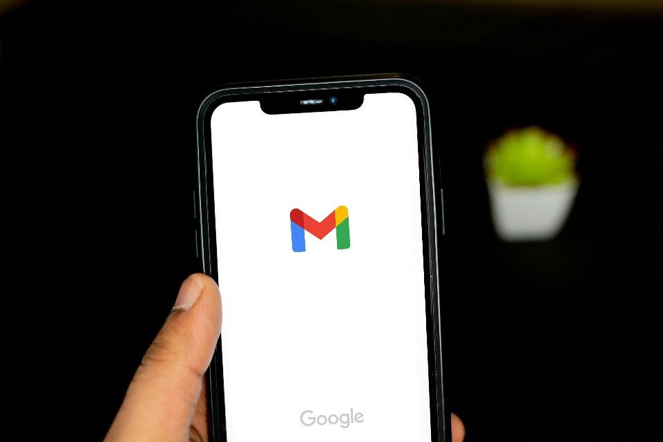 Person holding a phone with the Gmail logo on it