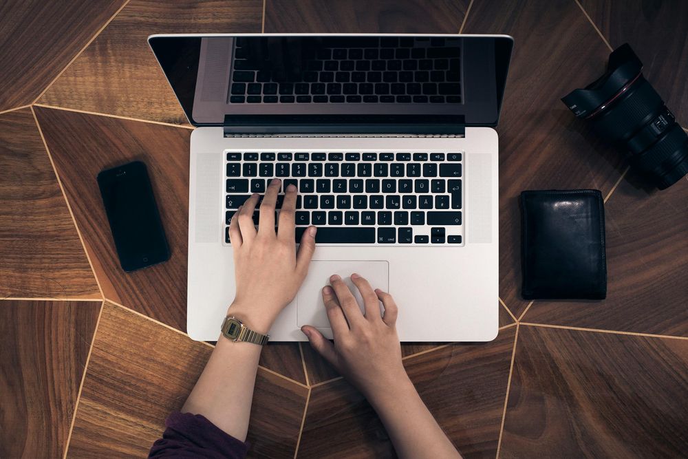 Person seen from above typing on a laptop