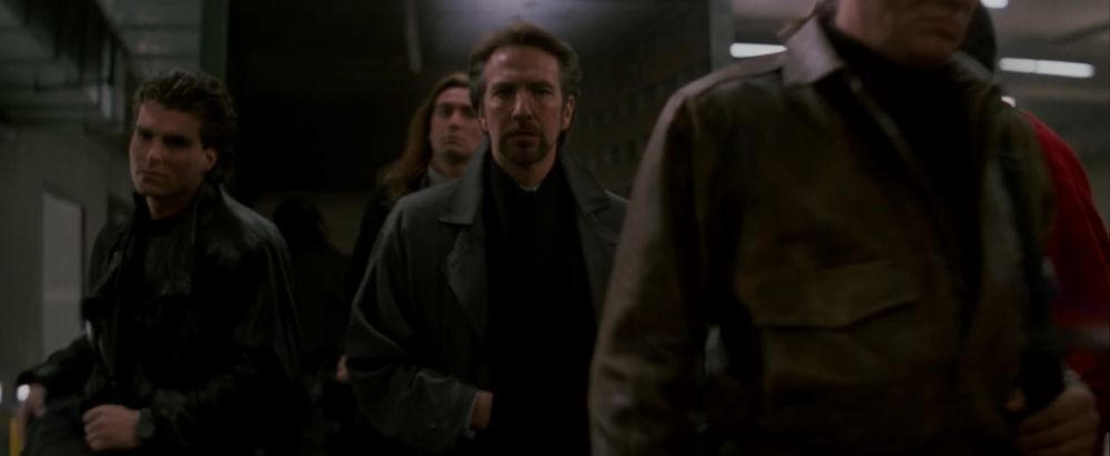 Hans Gruber (Alan Rickman) walks off the back of a truck with his band of terrorists in the Nakatomi Plaza parking garage during Die Hard (1988).
