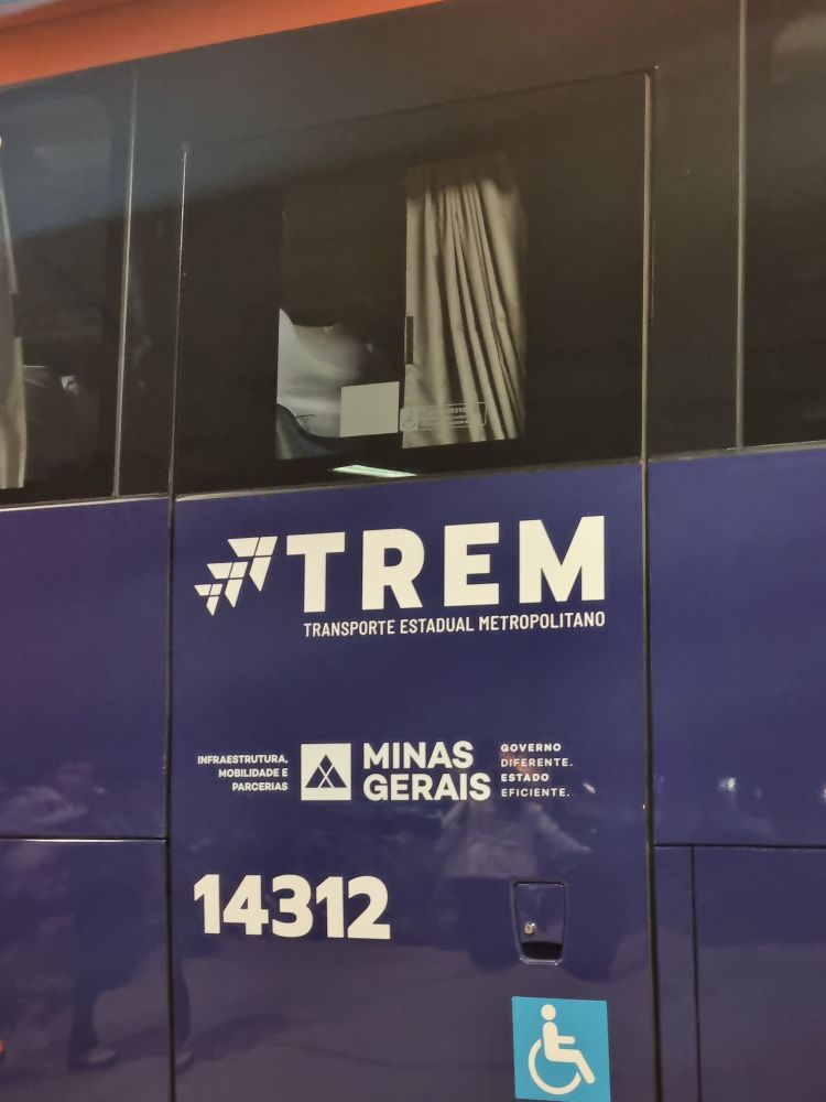 Lateral de ônibus com um adesivo contendo a sigla Trem: transporte estadual metropolitano