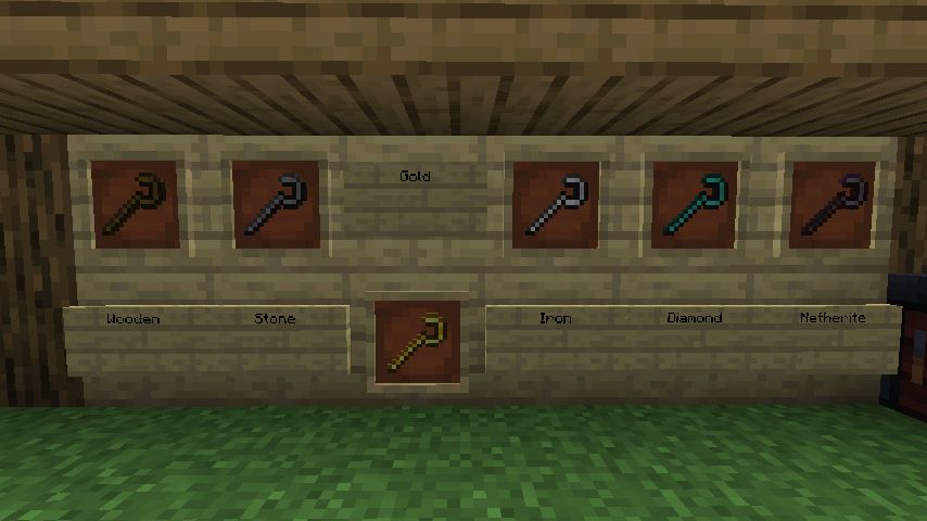 A wooden board on an grass surface with 6 crooks inside item frames placed on it. They're labelled: "Wooden", "Stone", "Gold" (with it being shifted down compared to the others), "Iron", "Diamond" and "Netherite". A smithing table is barely visible on the corner.
