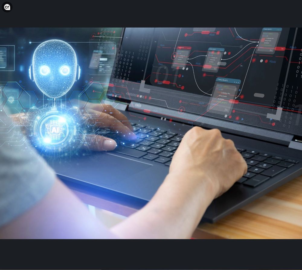 Person typing on a laptop with a blue/white figure of a robot on the top left hand side.