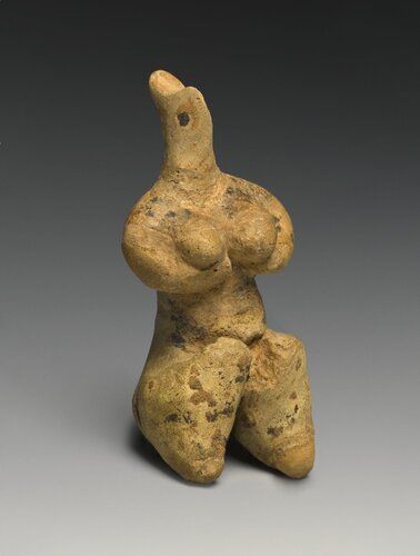 Painted terracotta figure of seated female; highly stylized head with pinched nose, elongated, pointed top (so-called polos type), eyes indicated by two large black masses; thick neck resting on broad shoulders extending as tubular arms which bend inward and support two huge breasts; black dots covering upper torso, breasts painted brown; very thick abdomen covered with tan and black spots; legs shown as extremely thick thighs tapering quickly to pointed feet, legs decorated with thickly applied black bands, some with masses of tan paint in between; back of statuette with single line of red paint running up spine and terminating in two oblique lines at shoulder blades creating form resembling an arrow, mass of dark paint at base of figure's rear.

