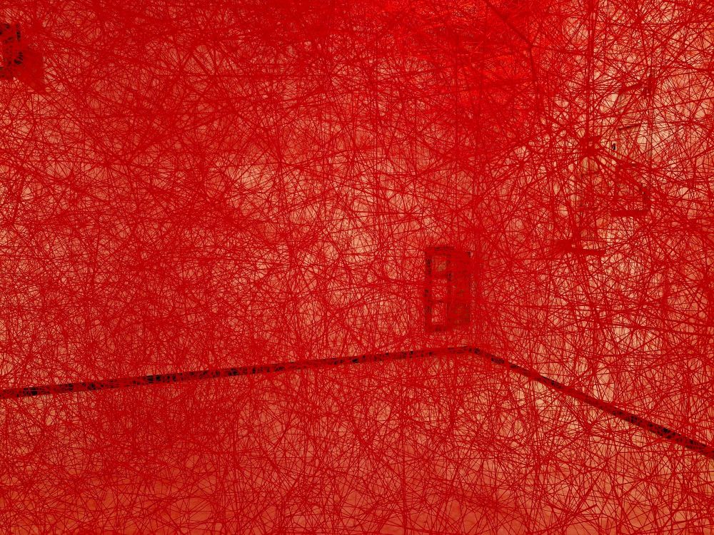 a densely-woven space of red threads in a gallery