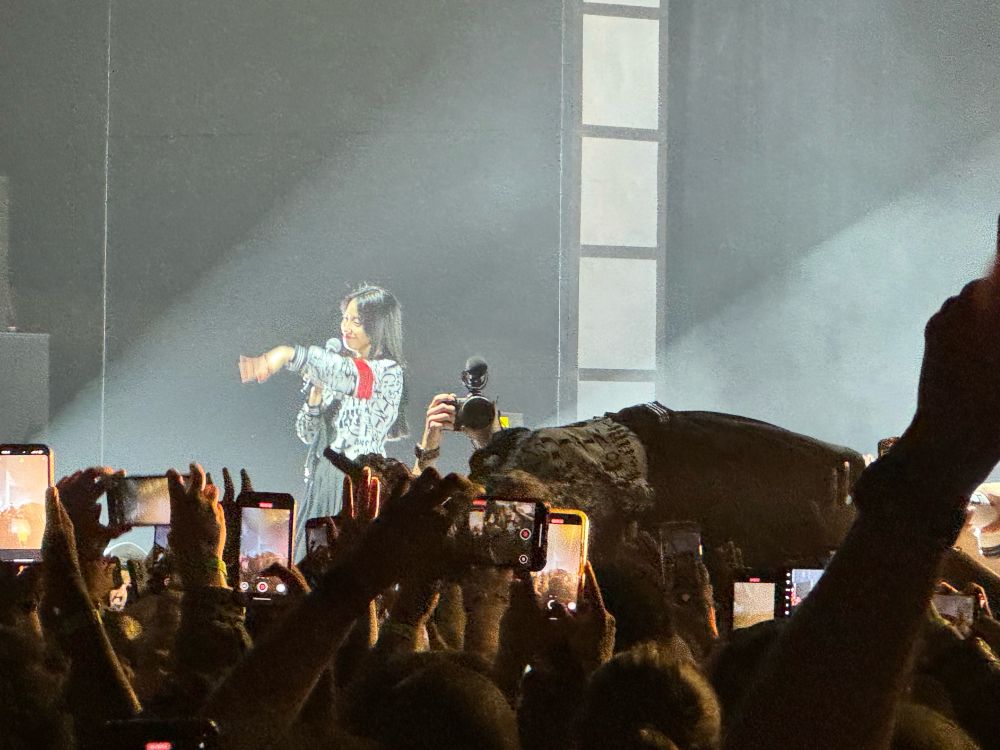 In foreground, Suzuka of ATARASHII GAKKO! crowdsurfs during their performance at The Anthem. In background, Kanon performs onstage.  
