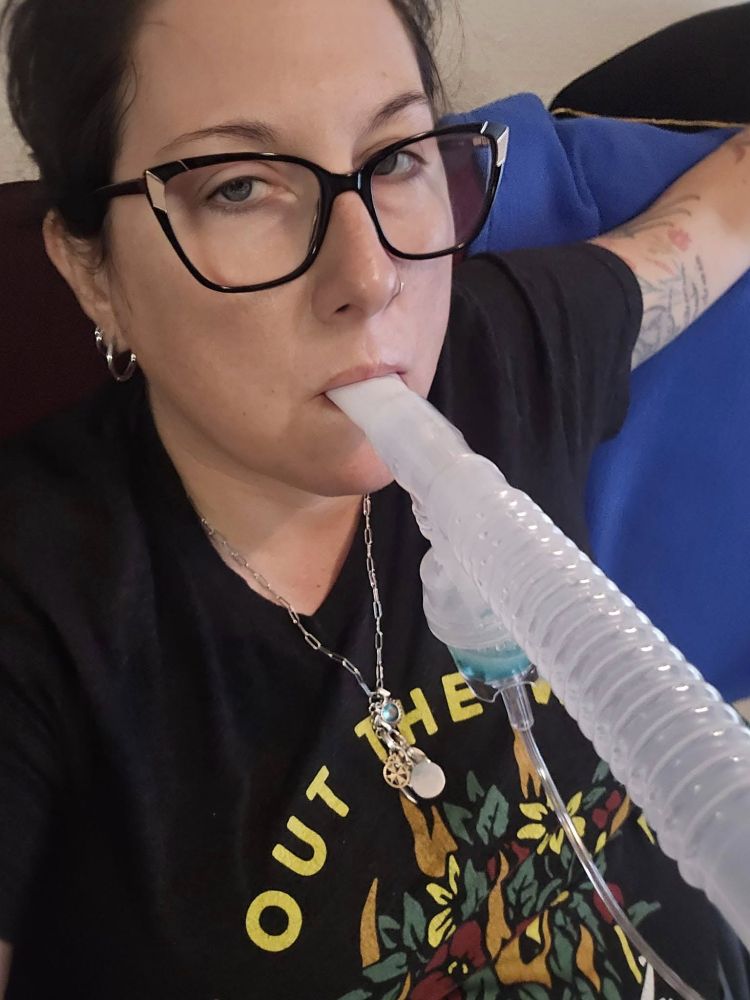 The author lounging on a couch using an asthma nebulizer to administer albuterol.