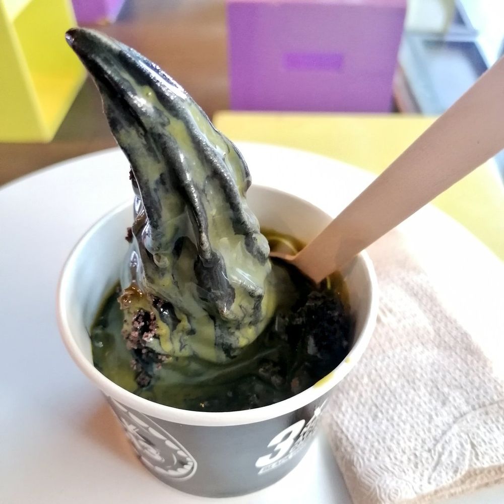 Yogurt with activated charcoal, topped with Matcha syrup and oreo lava rocks