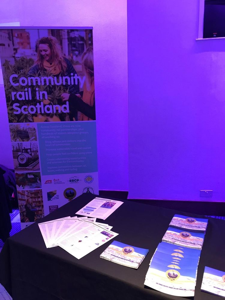 Photo showing a 'Community rail in Scotland' banner next to a table of leaflets and posters.
