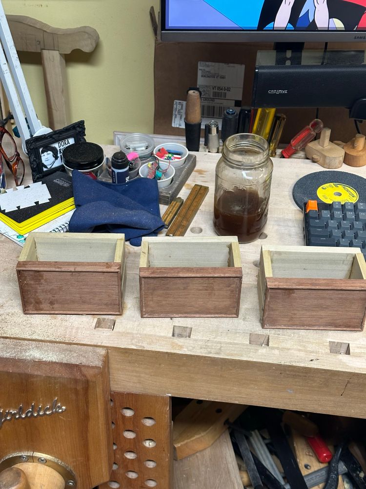 The three boxes side by side on a cluttered bench 