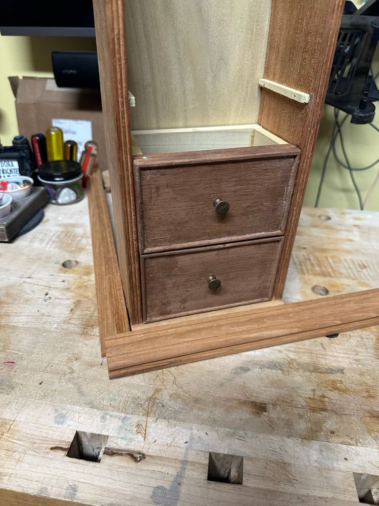 Mocking up the case with the uncut molding in place and a couple of drawers slid on their runners. The drawers are about 3” high and 5” wide and has an applied cockbeading there are tiny antiqued brass knobs. 