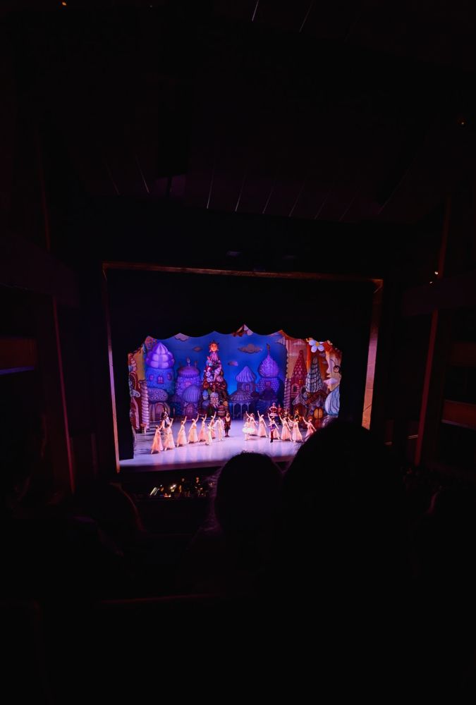 A stage in a theater with an extravagant set and dancers in costume. 