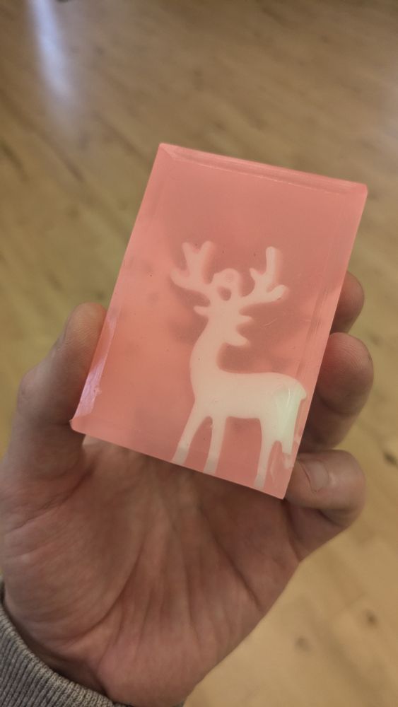 A soap with a deer inside and faint trees in the background. 