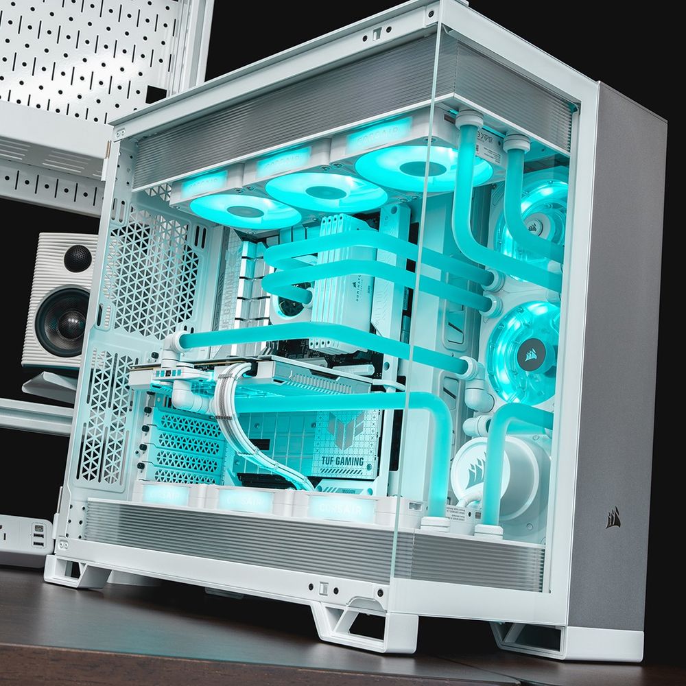 A CORSAIR 6500X with the glass side panel closed. The case features the Satin Grey Elite Panels, electric blue coolant, and all white PC internal parts. Parts include the Hydro X iCUE LINK XG7 GPU block, XD7 Pump, XC7 RGB ELITE LCD CPU block, and DOMINATOR TITANIUM RAM.