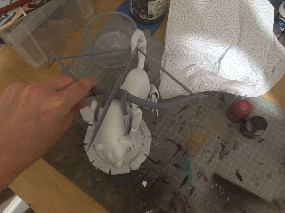 Photo of a figure of Gekigami, the tiger God from Okami. He’s resting his front paw on a rocky base and has a long bow on his back. Work in progress.