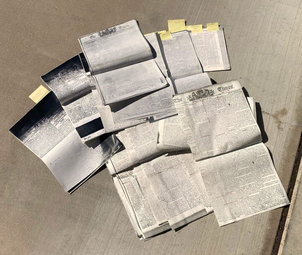 Scattered mass of phototopy pages (some with yellow Post-It notes, lying on a concrete surface. These are copies of pages from British newspapers & magazines covering the French Revolution (including London Times, Morning Chronicle, Morning Post, and Annual Register) that I harvested in the 1980s by printing page-parts from microfilm to a photocopier and then taping them together. I gathered these materials for my first monograph, Wordsworth: The Sense of History.