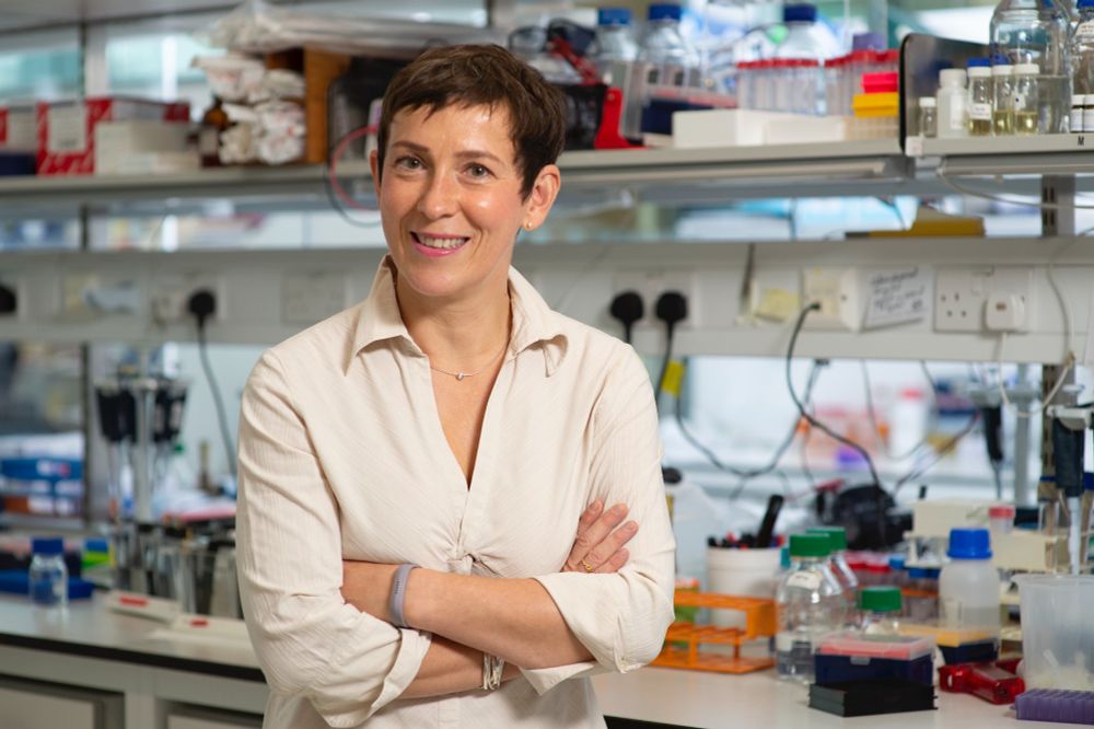 Anne Bertolotti, stood smiling in front of a lab bench