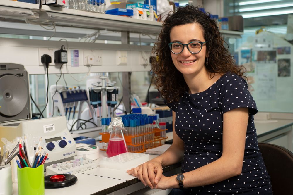 Marta Shahbazi, sitting in front of a lab bench