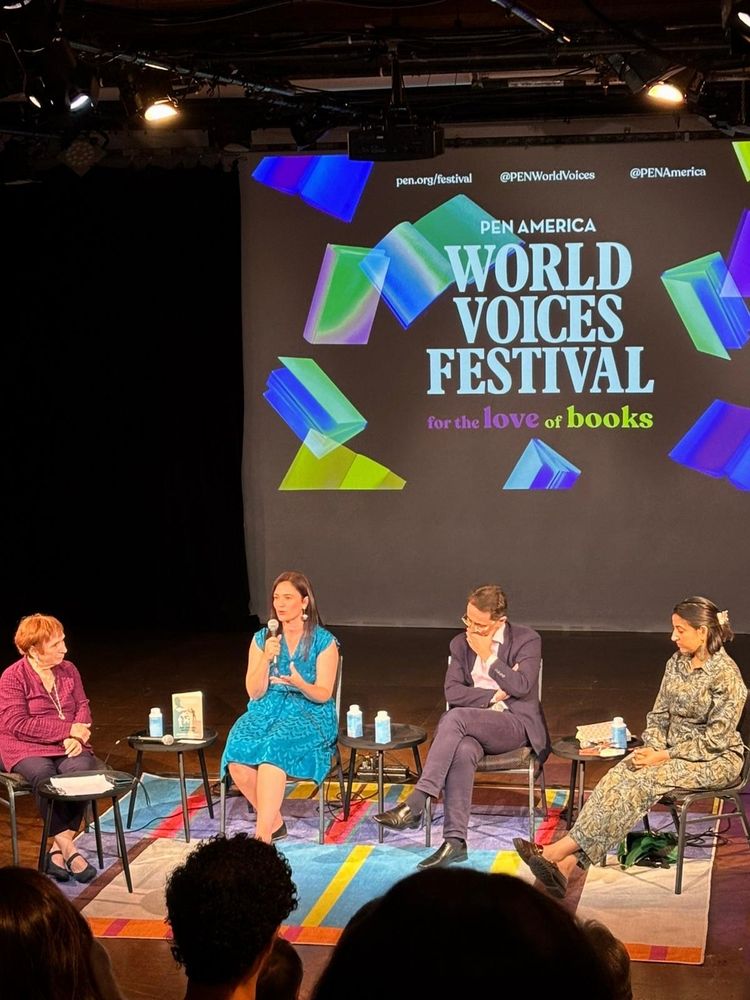 Panel of 4 people with PEN America World Voices Festival screen in background. L to R: Sandra Smith, Monica Cure (with microphone), Michael Eskin, and Sawad Hussain
