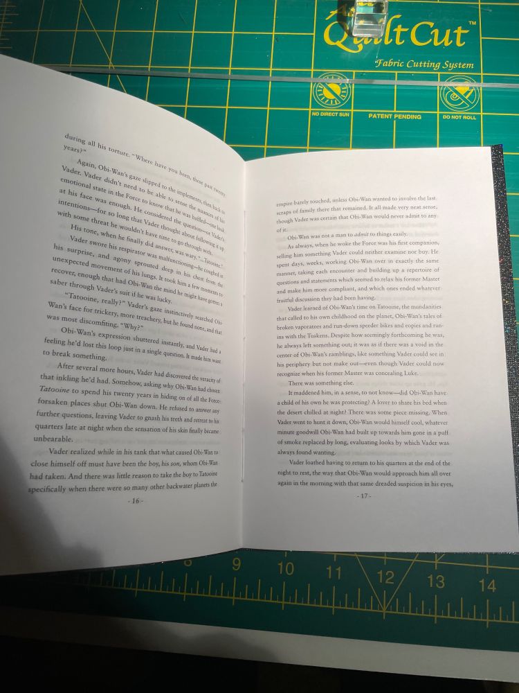 The middle of the booklet, with text filling both sides. White thread is visible down the middle where the spine is.