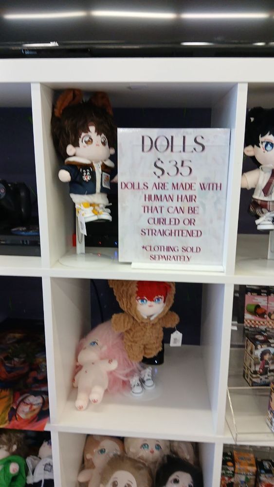 An Ikea bookcase full of unpleasant anime dolls with progeriac toddler proportions. "DOLLS. 35$ DOLLS ARE MADE WITH HUMAN HAIR THAT CAN BE CURLED OR STRAIGHTENED. *CLOTHING SOLD SEPERATELY."