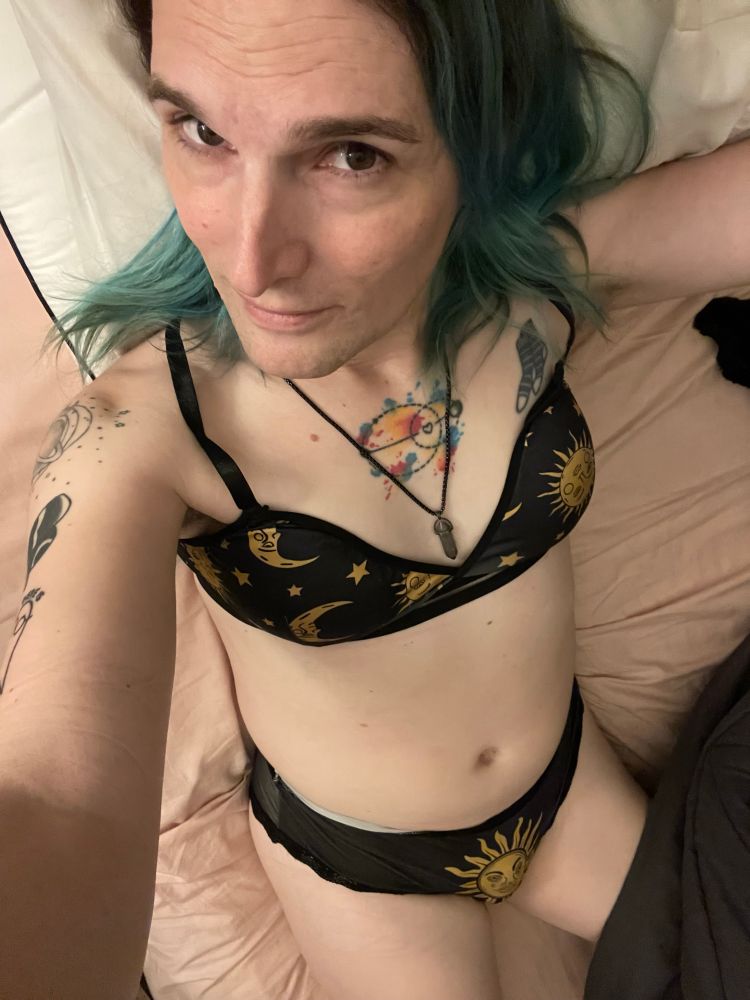 Emily wearing a bra and panties set that is black with sun star and moon print on it