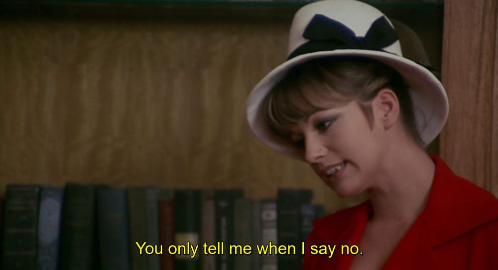 Catherine Spaak usando um paletó vermelho e um chapéu branco dizendo: Só me chamam disso quando eu digo não.