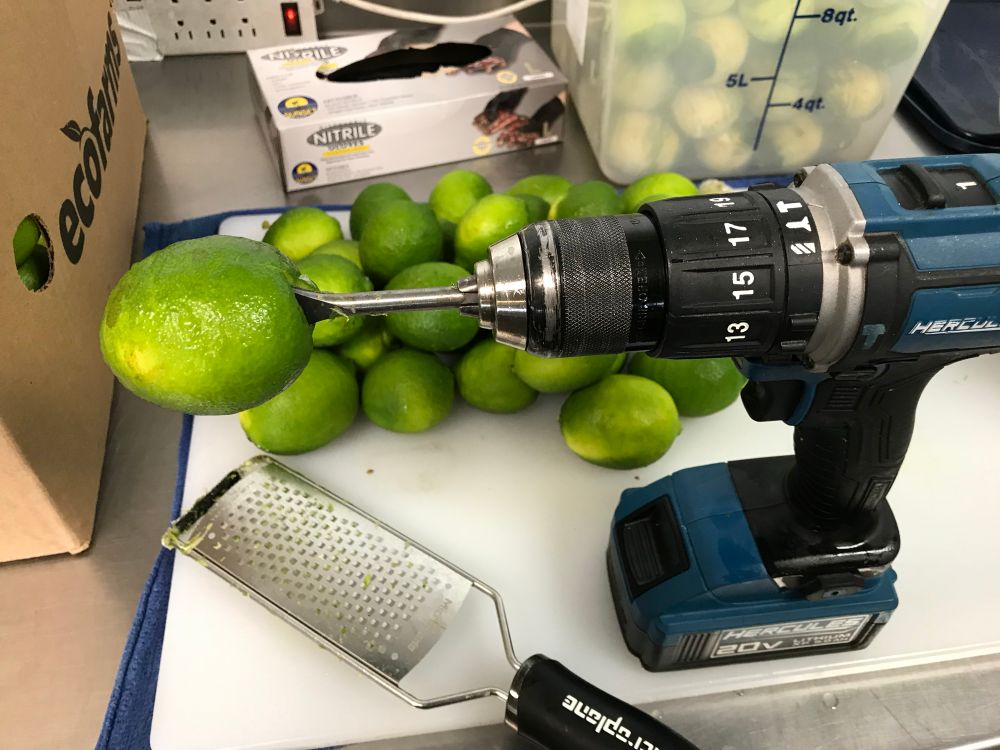 limes ready for zesting. one is spiked on a spade bit