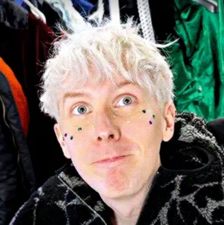 phil from the phantasy calendar video wearing dans hoodie with glitter and gems on his face