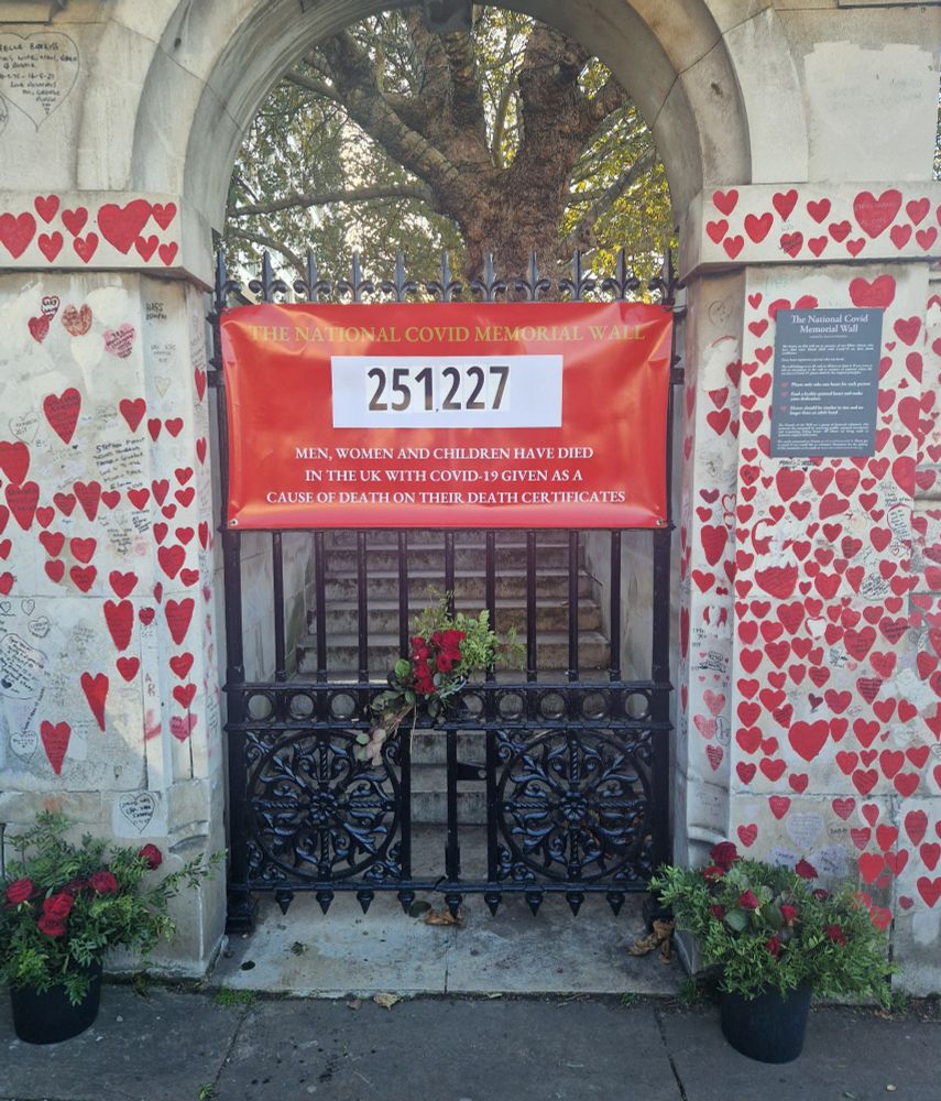 The red banner on a the gate at the memorial wall showing the number of covid dead. The figure reads 251,227