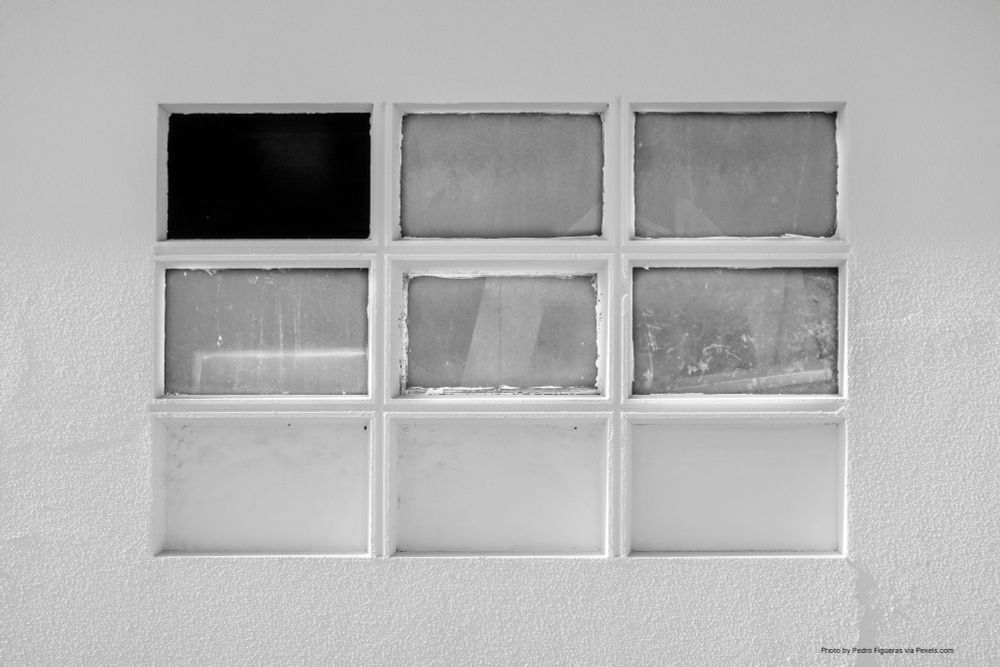 a black and white photograph of a 3x3 grid of window panes of varying trascluscence