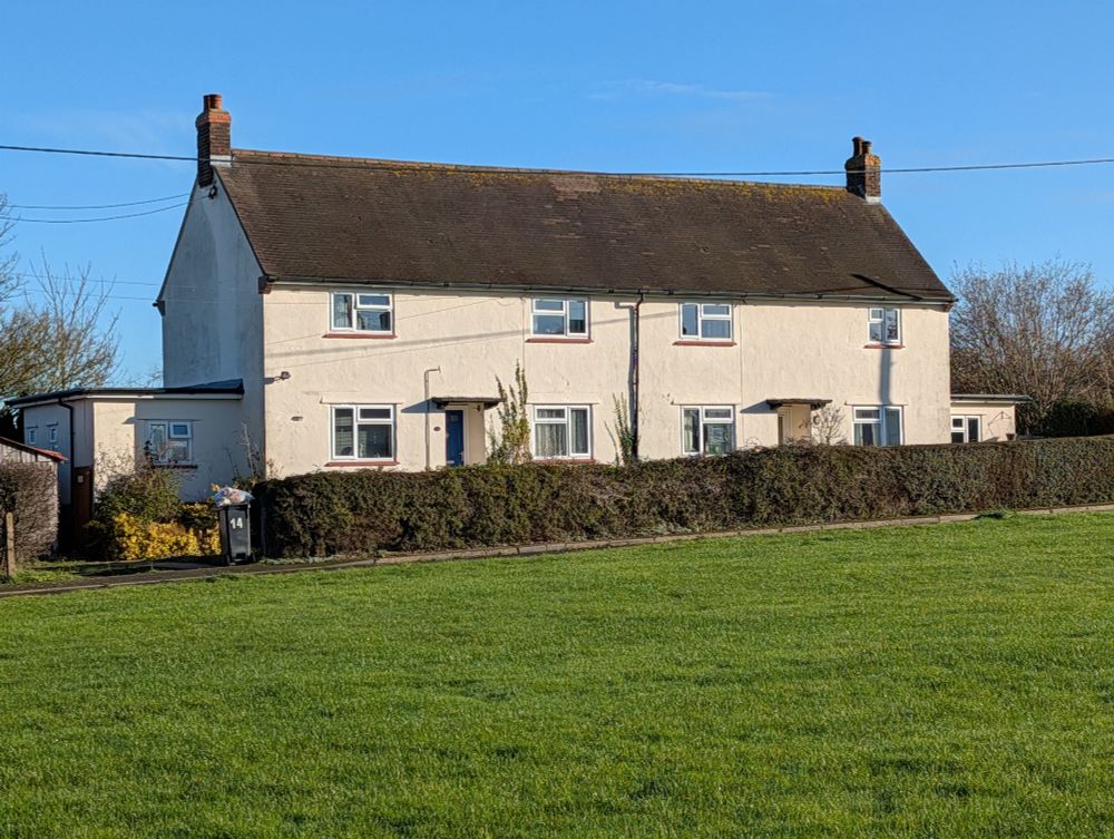 Semi-detached pair of double-fronted, white-rendered council houses