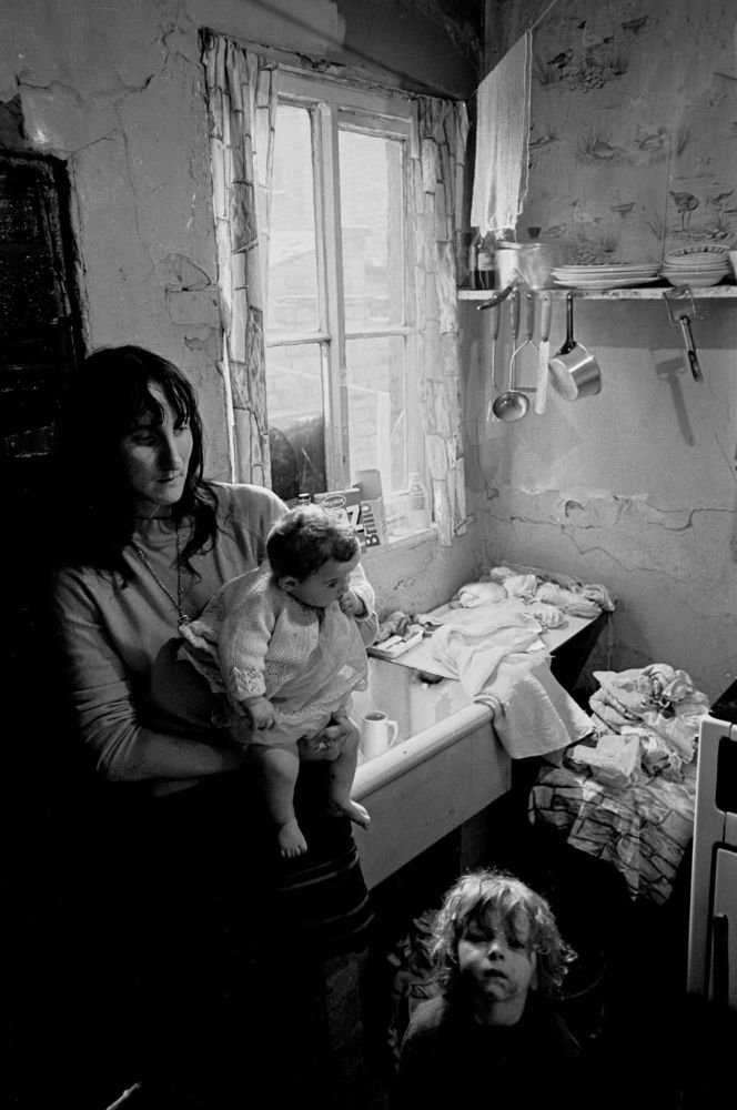 Salford 1971. Mother and child in slum kitchen.
