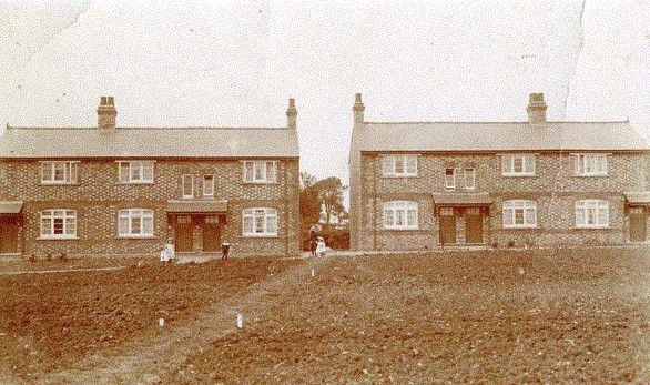 1912 postcard of two three-house terrace blocks and communal gardens