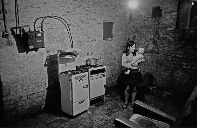 Manchester, 1968. Mother and child in slum kitchen 