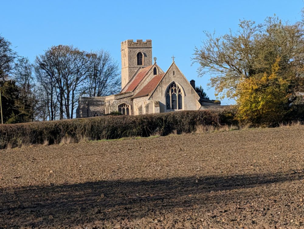 View of church over ploughed field