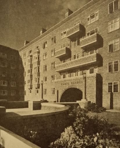 Courtyard view of Caryl Gardens, six-storey tenement block, and arched entrance