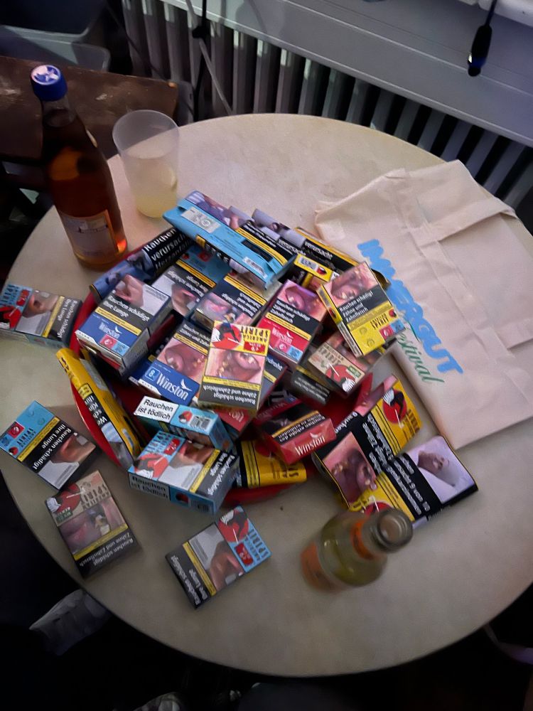 ein tisch voller kippenschachteln und drehtabak