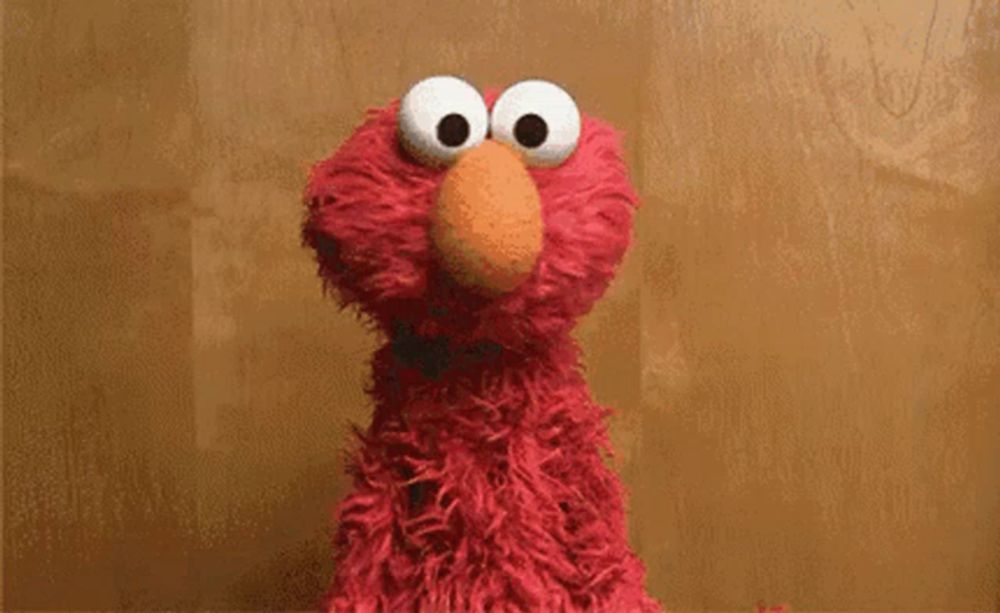 elmo from sesame street says " i 'm an idiot " on a brown background