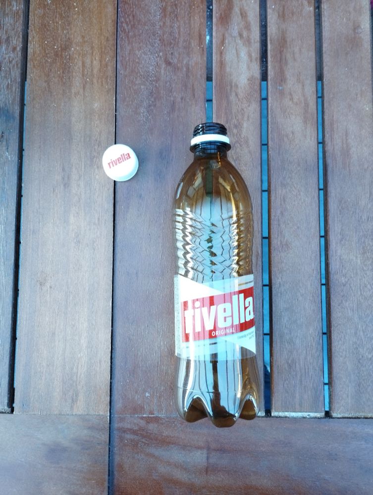 Eine pet-flasche von rivella, der Deckel ist nicht fest am Flaschenhals.