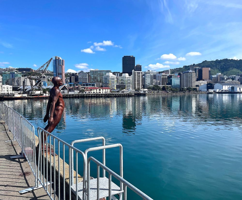 Bronze Sculpture of naked swimmer about to dive into Wellington inner Harbour on sunny day