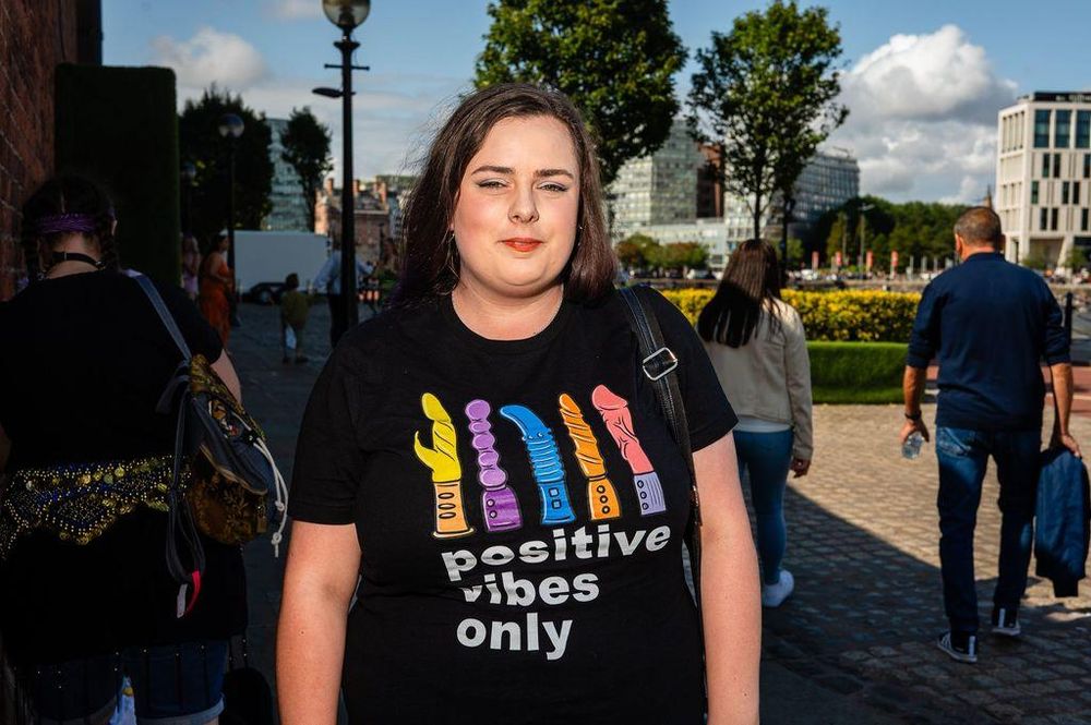 A woman wearing a 'Positive Vibes Only' t-shirt with drawings of dildos on at Liverpool Pride.