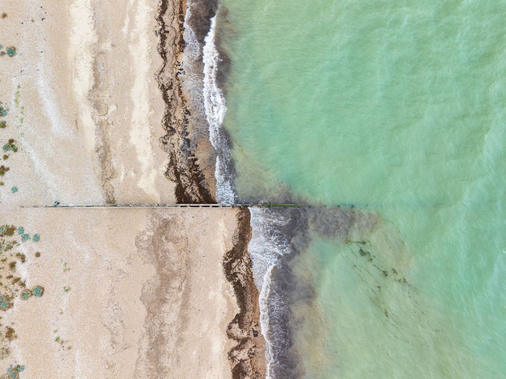 Aerial view of Littlehampton beach, showcasing the sandy shore meeting the turquoise waters of the English Channel.
