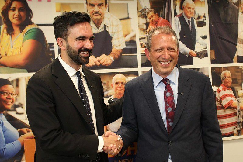 Zohran Mamdani and Brad Lander smile and shake hands after cross-endorsing for the 2025 Democratic mayoral primary.