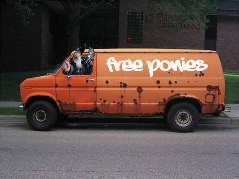 A rusty orange van, with "free ponies" painted on the side. Vermin Supreme leans out the driver's window with his megaphone, pointing at someone near the camera.
