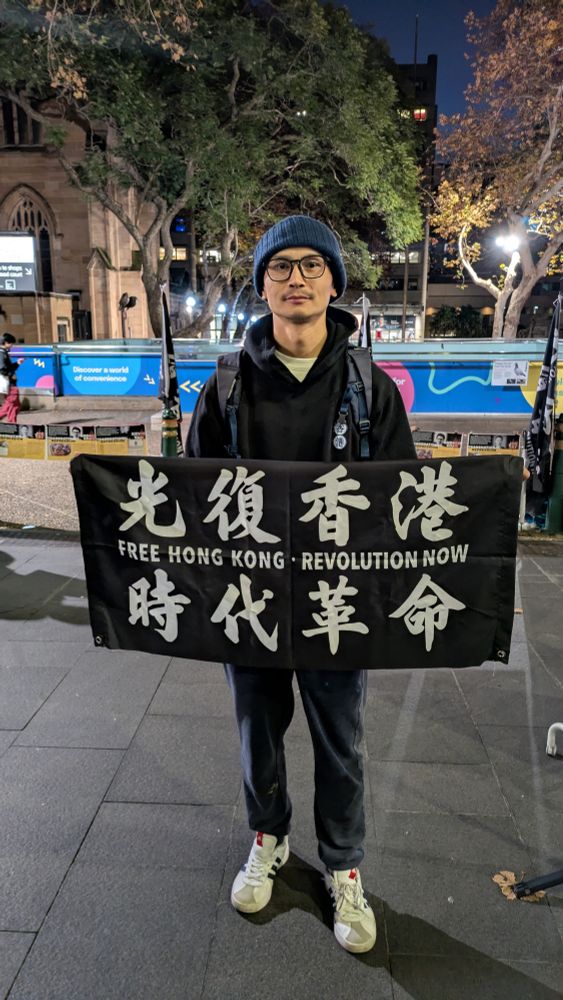 Man with a flag saying free Hong Kong Revolution Now 