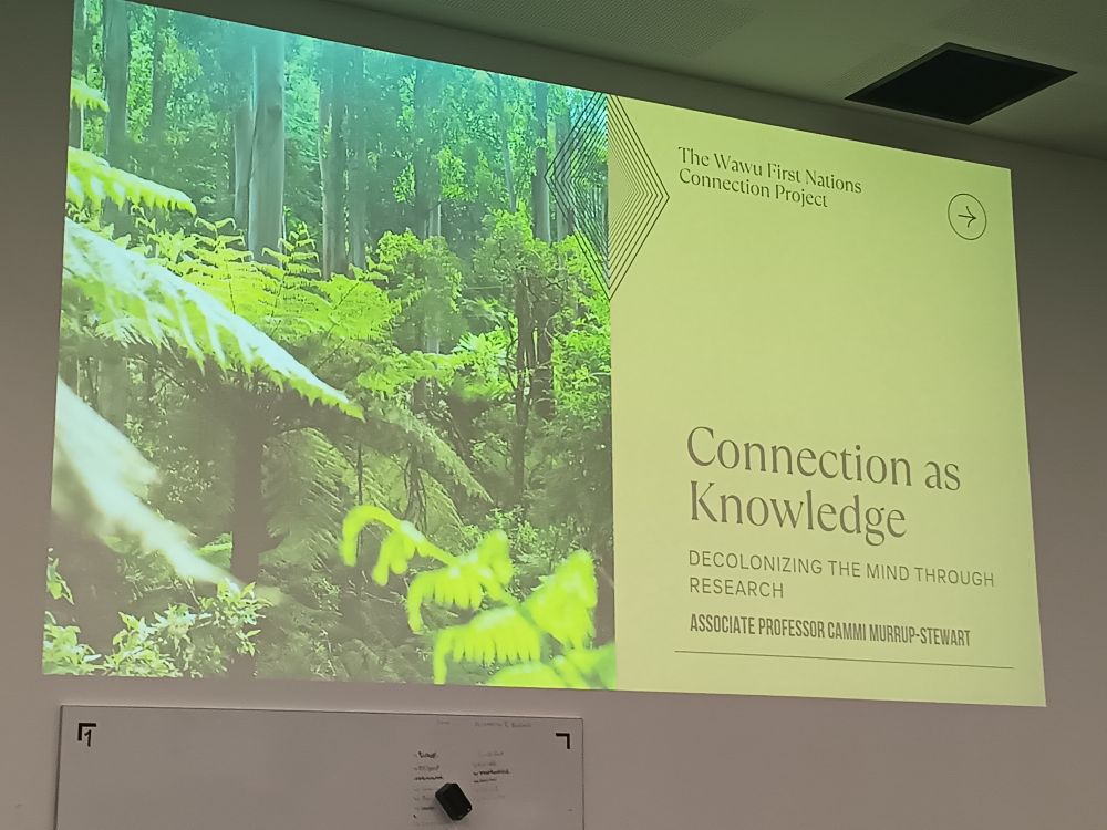 Title slide for Cammi Murrup-Stewart's keynote talk. It depicts a forest with the title "Connection as Knowledge" and subtitle "Decolonizing the mind through research"