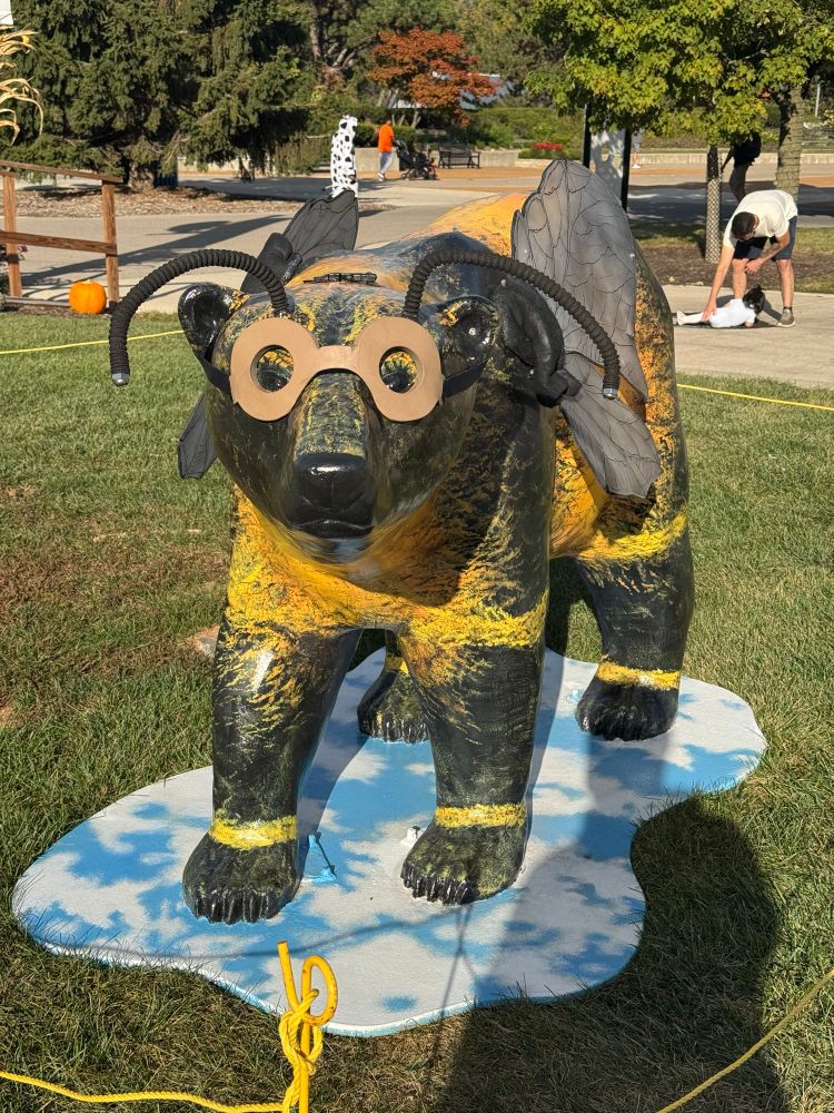 A statue of a bear wearing a bee costume.