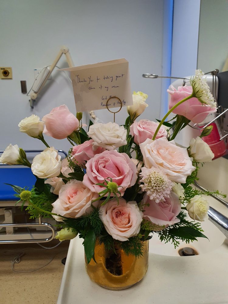 A bouquet of pink, cream and white roses in a clinic room. 