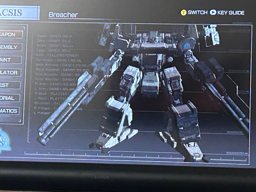 A front on view of Breacher, an Armored Core from Armored Core 4. It is a heavily armored mech with two legs, it carries two bazookas in its arms and missiles on its back. 